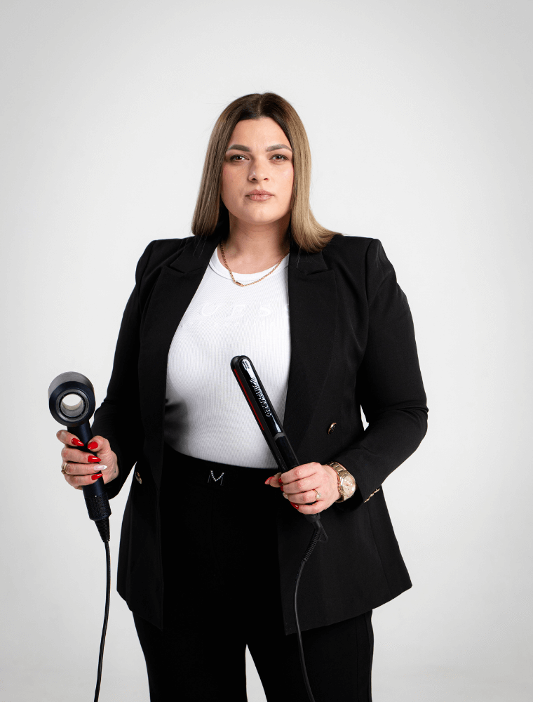 Profesionali plaukų priežiūros specialistė su plaukų formavimo įrankiais, minimalistinis studijos fonas